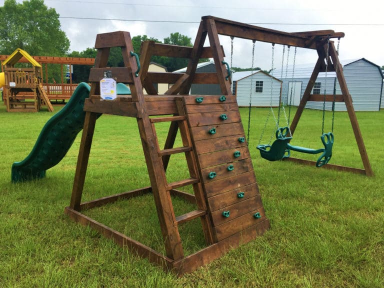 green backyard swing set with climbing wall
